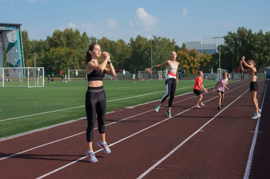 Group of young athletes training at the stadium. School gym trainings or athletics