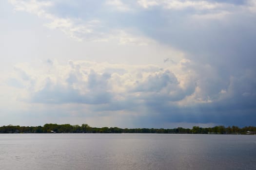 Dramatic clouds and serene lake at Winona Lake, Indiana, hint at an approaching storm.