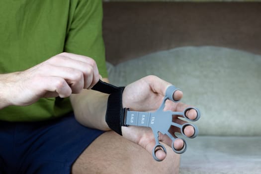 Hands are put on silicone finger trainer with special velcro fastening to extend the fingers and strengthen the hands