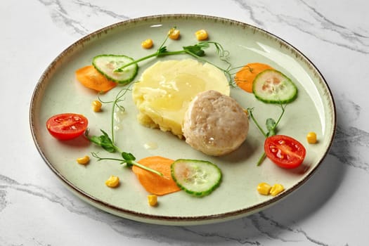 Steamed fish patty served with creamy mashed potatoes garnished with slices of fresh carrot, cucumber, cherry tomatoes and green pea sprouts. Delicious healthy dinner for kids. Restaurant menu