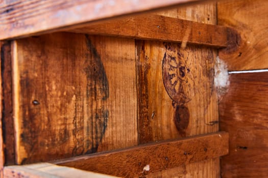 Close-up of weathered wooden boards with vintage stamps, evoking rustic charm and historical depth.