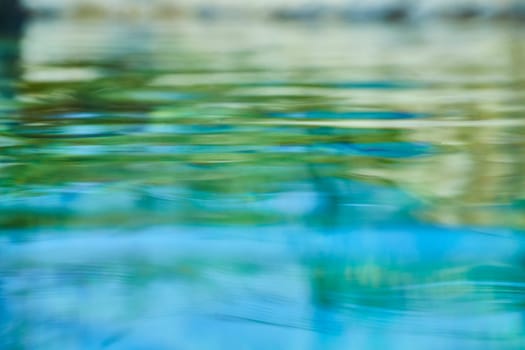 Serene water reflections at Fort Wayne, Indiana: a blend of blue and green hues evoking tranquility and nature's fluid artistry.