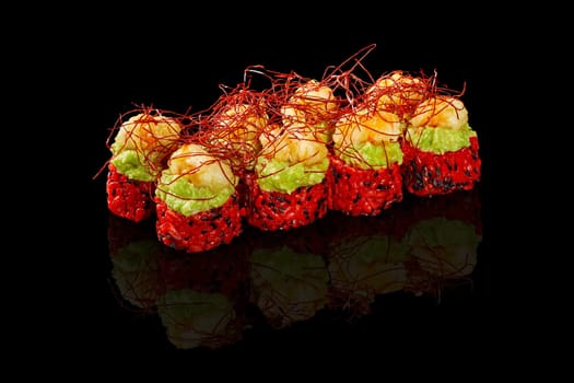 Enticing vibrant red rice sushi rolls topped with avocado spread and shrimp tempura garnished with spicy togarashi threads, presented on black background. Japanese menu concept