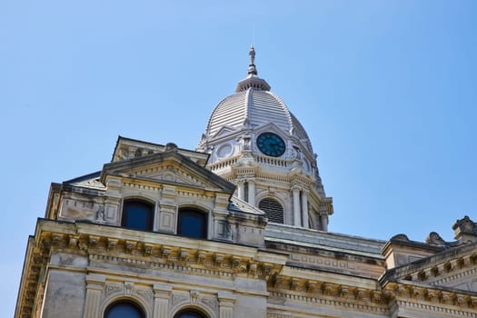 Elegant Kosciusko County Courthouse dome and clock, Warsaw, under a clear blue sky.