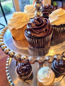 Elegant cupcakes on a metallic stand, showcased in a cozy Fort Wayne bakery setting. Perfect for culinary art promotions.