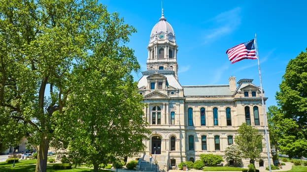 Majestic Kosciusko County Courthouse in Warsaw, Indiana under a clear blue sky, symbolizing tradition and authority.