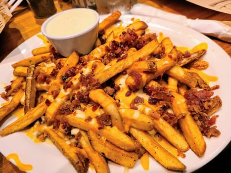 Crispy loaded fries with cheddar and bacon, served with ranch, in Fort Wayne, capturing indulgence and comfort.