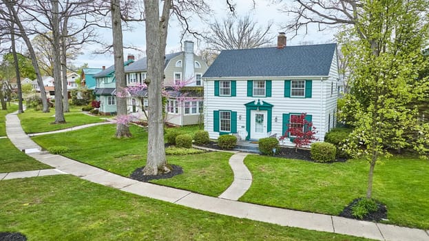 Spring in Fort Wayne: Aerial view of serene suburban homes with lush gardens, perfect for real estate showcases.