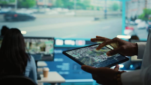 Manager tracking a delivery car by using satellite map for navigating around the city, monitoring orders via surveillance footage and CCTV system. Locating coordinates for shipping route. Camera B.