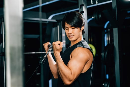 An adult bodybuilder in the gym doing cable triceps pull-up with a heavy weight, showcasing his strength and power. lifestyle and people concept