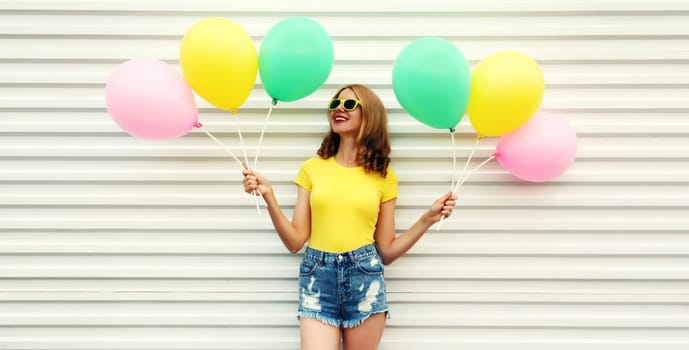 Summer, holiday, celebration, happy cheerful young woman with bright colorful balloons having fun on white background