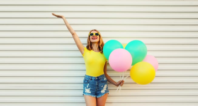 Summer, holiday, celebration, happy cheerful young woman with bright colorful balloons having fun on white background