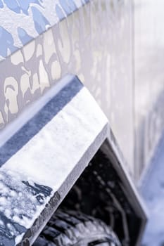 Denver, Colorado, USA-May 5, 2024-This image features a close-up view of the Tesla Cybertruck wheel and angular body design covered in soap and water during a thorough car wash, highlighting the unique textures and robust details of the electric truck.