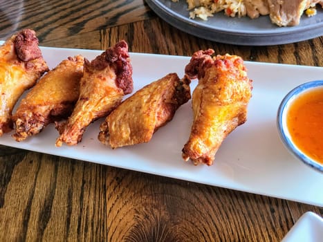 Crispy fried chicken with spicy sauce in a cozy Fort Wayne diner, perfect for a flavorful meal.