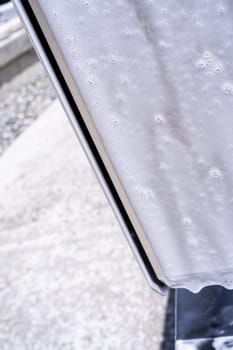 Denver, Colorado, USA-May 5, 2024-This image captures soapy water streaming beautifully down the metallic, angular side of a Tesla Cybertruck during a wash. The close-up showcases the sleek lines and unique design of the vehicle.