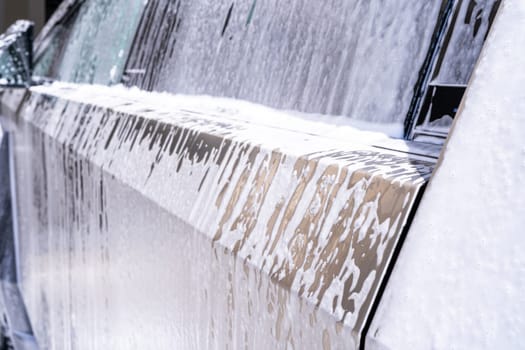 Denver, Colorado, USA-May 5, 2024-This image captures soapy water streaming beautifully down the metallic, angular side of a Tesla Cybertruck during a wash. The close-up showcases the sleek lines and unique design of the vehicle.