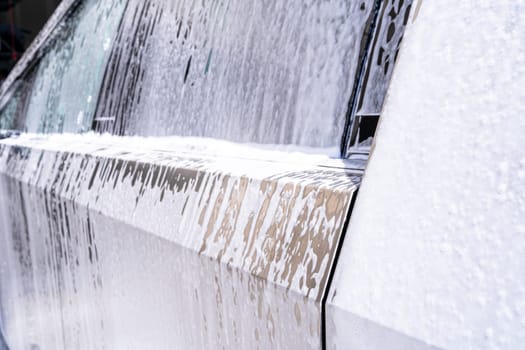 Denver, Colorado, USA-May 5, 2024-This image captures soapy water streaming beautifully down the metallic, angular side of a Tesla Cybertruck during a wash. The close-up showcases the sleek lines and unique design of the vehicle.