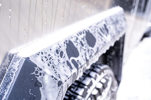 Denver, Colorado, USA-May 5, 2024-This image features a close-up view of the Tesla Cybertruck wheel and angular body design covered in soap and water during a thorough car wash, highlighting the unique textures and robust details of the electric truck.