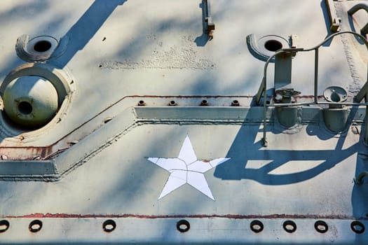 Close-up of a weathered star emblem on a military tank, symbolizing endurance and history.