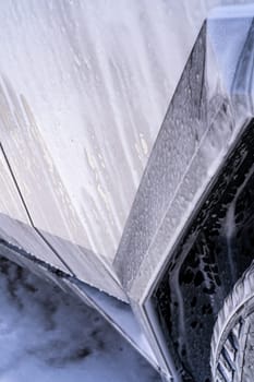 Denver, Colorado, USA-May 5, 2024-This image features a close-up view of the Tesla Cybertruck wheel and angular body design covered in soap and water during a thorough car wash, highlighting the unique textures and robust details of the electric truck.