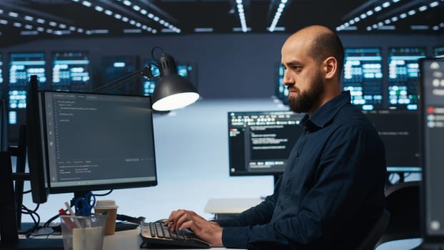 Software developer programming in high tech facility with server rows providing computing resources for different workloads. IT expert reviewing data center supercomputers