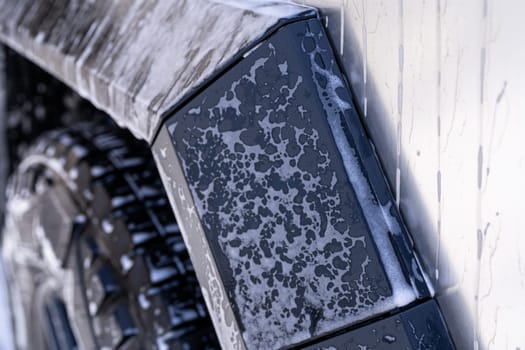 Denver, Colorado, USA-May 5, 2024-This image features a close-up view of the Tesla Cybertruck wheel and angular body design covered in soap and water during a thorough car wash, highlighting the unique textures and robust details of the electric truck.