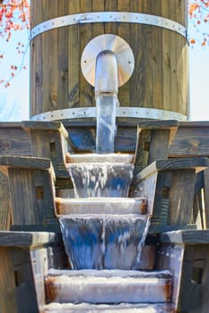 Rustic wooden water feature at Fort Wayne, Indiana flows gently in a serene garden setting.