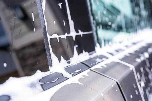 Denver, Colorado, USA-May 5, 2024-This image captures soapy water streaming beautifully down the metallic, angular side of a Tesla Cybertruck during a wash. The close-up showcases the sleek lines and unique design of the vehicle.