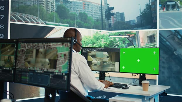 African american employee using CCTV security system and mockup screen, monitoring traffic through real time video surveillance footage in observation room. Expert ensures public safety. Camera B.