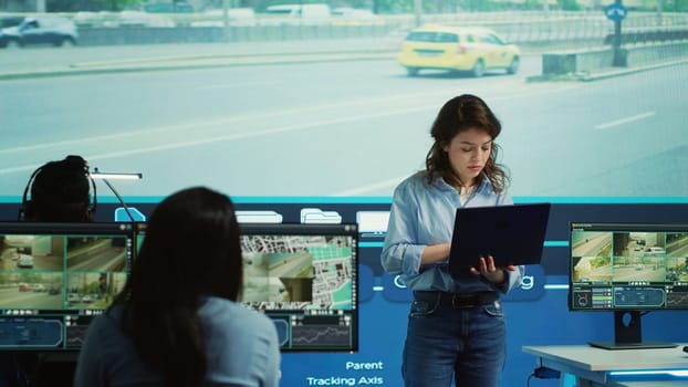 Young manager analyzing traffic surveillance data with her employees team, using the CCTV security system around the city. Agency experts employing satellite radars for reconnaissance. Camera A.