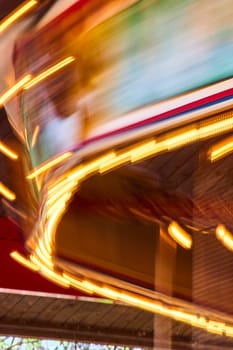 Vibrant carousel lights blur into streaks of color, capturing the festive spirit of Fort Wayne's night scene.