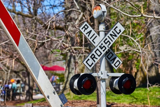 Railroad crossing sign with alert lights at a lively park near Fort Wayne Children's Zoo, Indiana.