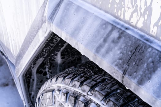 Denver, Colorado, USA-May 5, 2024-This image features a close-up view of the Tesla Cybertruck wheel and angular body design covered in soap and water during a thorough car wash, highlighting the unique textures and robust details of the electric truck.