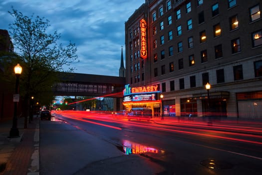Twilight over Fort Wayne: Neon lights of Embassy Theatre illuminate a bustling downtown street.