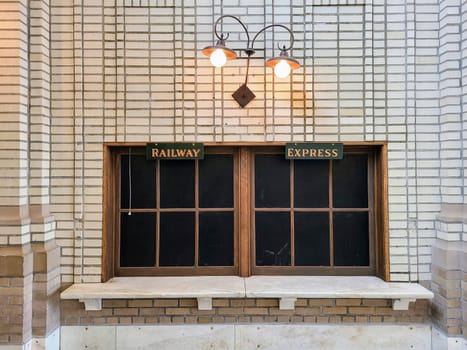 Vintage Railway Express window at a historic Fort Wayne station, bathed in warm light, evoking timeless charm.