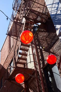 Vibrant red lanterns contrast a rustic urban backdrop in downtown Fort Wayne, capturing a festive city vibe.