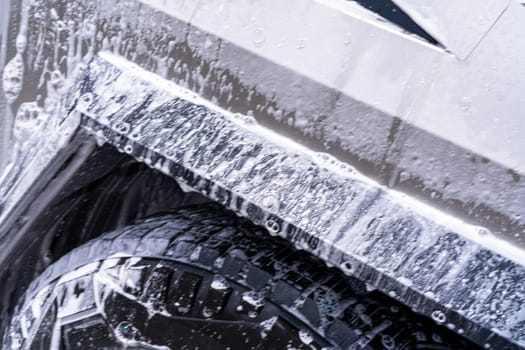 Denver, Colorado, USA-May 5, 2024-This image features a close-up view of the Tesla Cybertruck wheel and angular body design covered in soap and water during a thorough car wash, highlighting the unique textures and robust details of the electric truck.