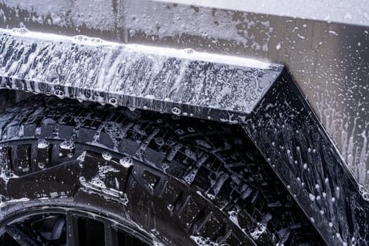 Denver, Colorado, USA-May 5, 2024-This image features a close-up view of the Tesla Cybertruck wheel and angular body design covered in soap and water during a thorough car wash, highlighting the unique textures and robust details of the electric truck.