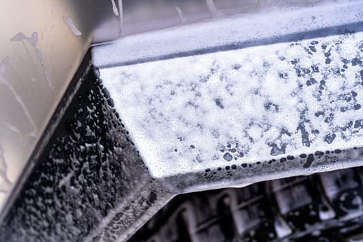 Denver, Colorado, USA-May 5, 2024-This image features a close-up view of the Tesla Cybertruck wheel and angular body design covered in soap and water during a thorough car wash, highlighting the unique textures and robust details of the electric truck.