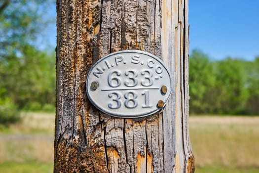 Rustic utility sign on a wooden pole in Warsaw, Indiana, symbolizing rural American life and land management.