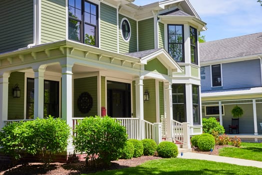 Charming sage green home in Fort Wayne's historic West Central neighborhood, showcasing elegant architecture and lush landscaping.