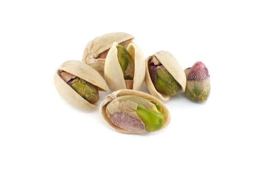 Pistachios are randomly spread across the white surface, some pistachios being in-shell and others peeled exposing the green nuts inside