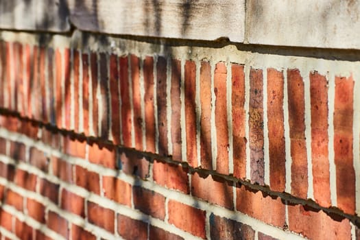 Textured close-up of an aged brick wall in Fort Wayne, showcasing a history of resilience and time.