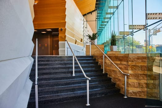 Elegant staircase in a modern office with glass walls, reflecting downtown Fort Wayne.