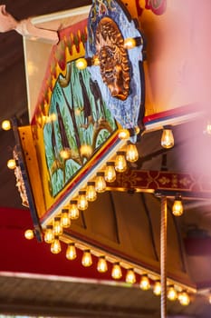 Illuminated vintage carousel at Fort Wayne Children's Zoo, featuring a regal lion and festive lights.
