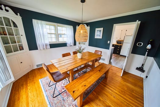 Cozy, modern rustic dining room in a Fort Wayne home, featuring navy accent walls and natural wood furnishings.