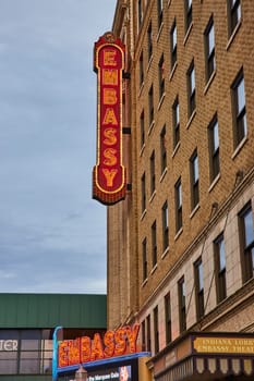 Illuminated EMBASSY neon signs glow against an overcast sky at the historic Embassy Theatre, Fort Wayne.