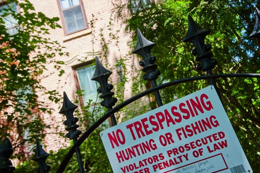 No Trespassing sign on an ornate gate in a historic Fort Wayne neighborhood, emphasizing privacy and legal boundaries.