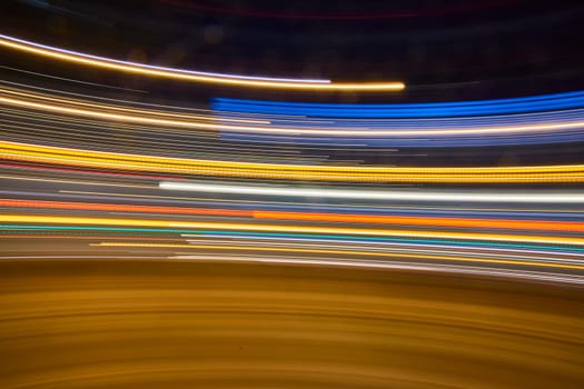 Vibrant light trails swirl through downtown Fort Wayne, capturing the energy of urban nightlife in motion.
