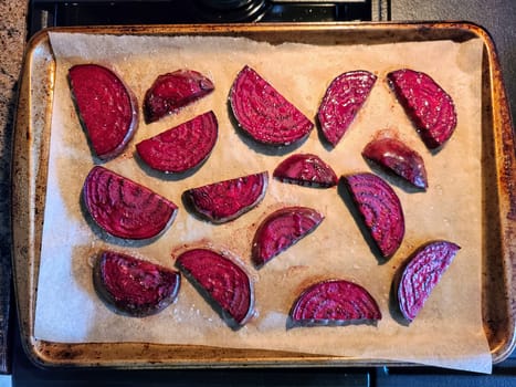 Vibrant beetroot slices on parchment, seasoned from baking, embody fresh, healthy home cooking.